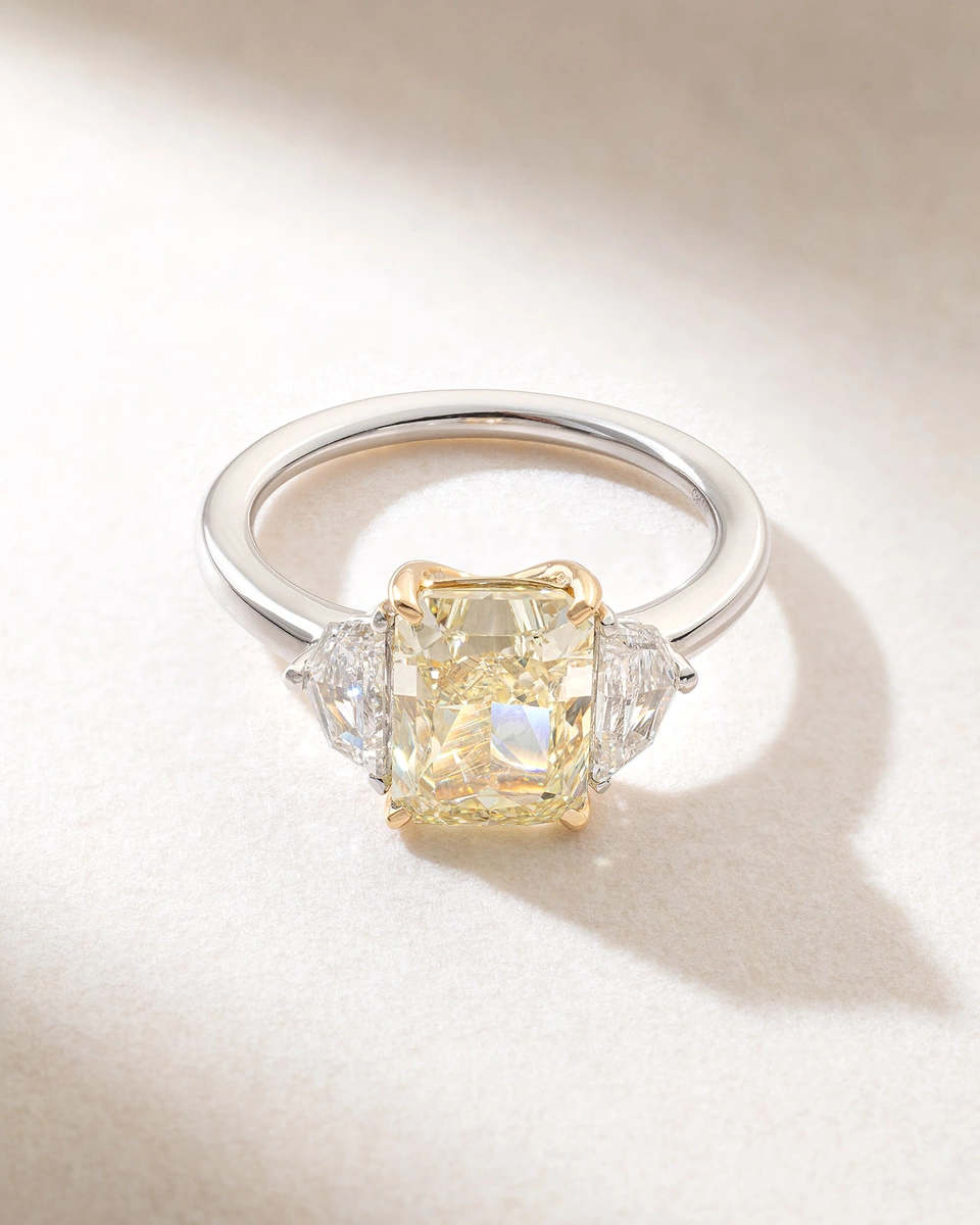 Exquisite 18K White Gold Ring with a Fancy Yellow Radiant Diamond and Two Trapezoid Diamonds