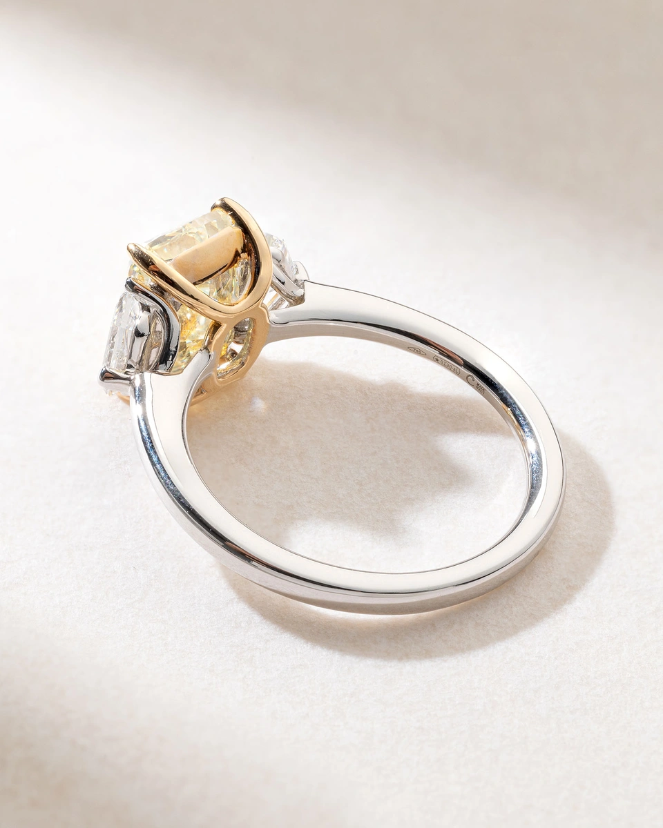 Exquisite 18K White Gold Ring with a Fancy Yellow Radiant Diamond and Two Trapezoid Diamonds